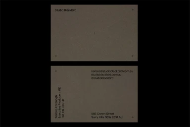 Front and back views of a minimal dark grey business card for Studio Blackbird with clean typography and crop marks.