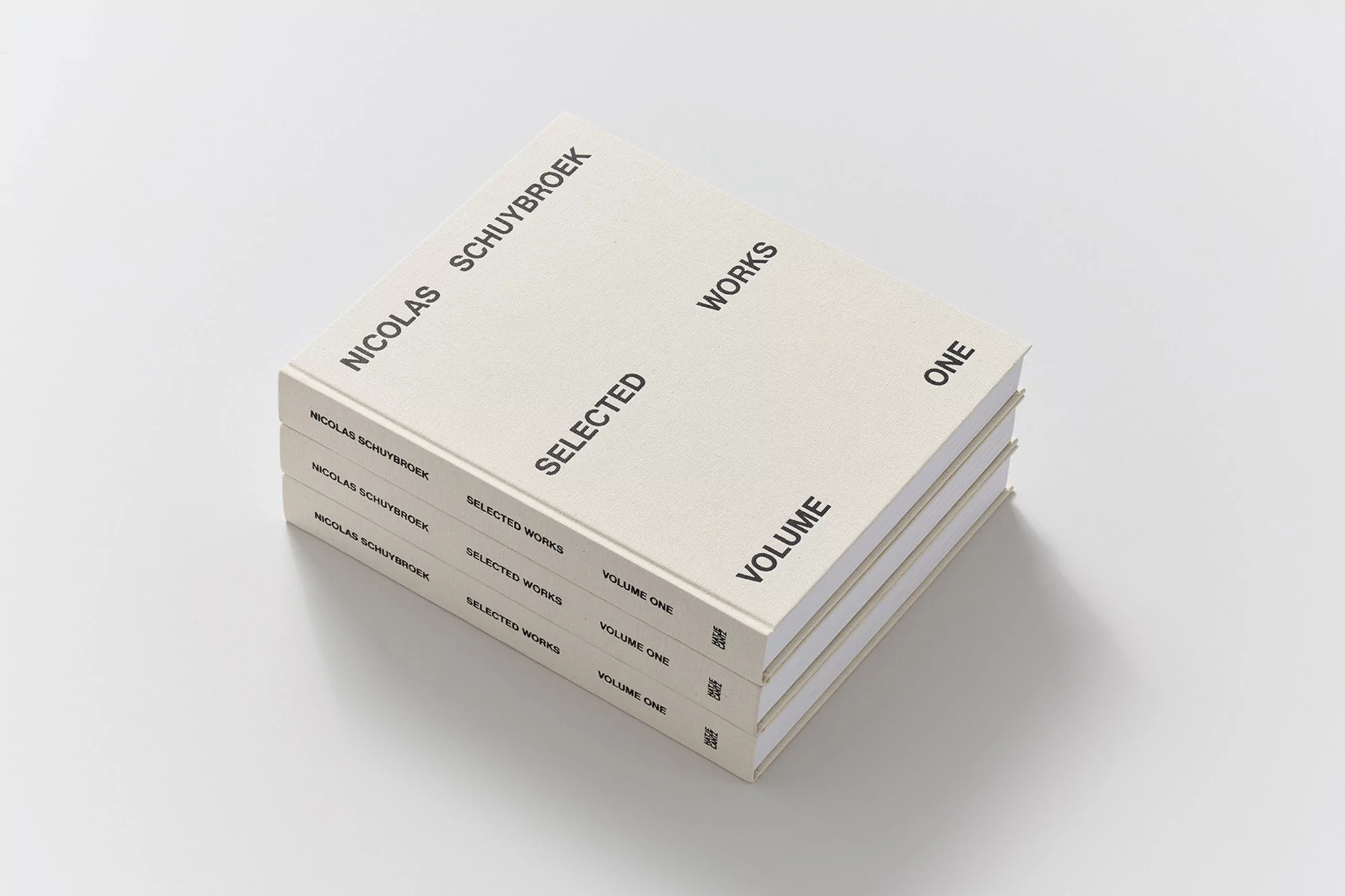 Stack of three 'Nicolas Schuybroek: Selected Works, Volume One' books on a white surface. Minimalist design with black text.
