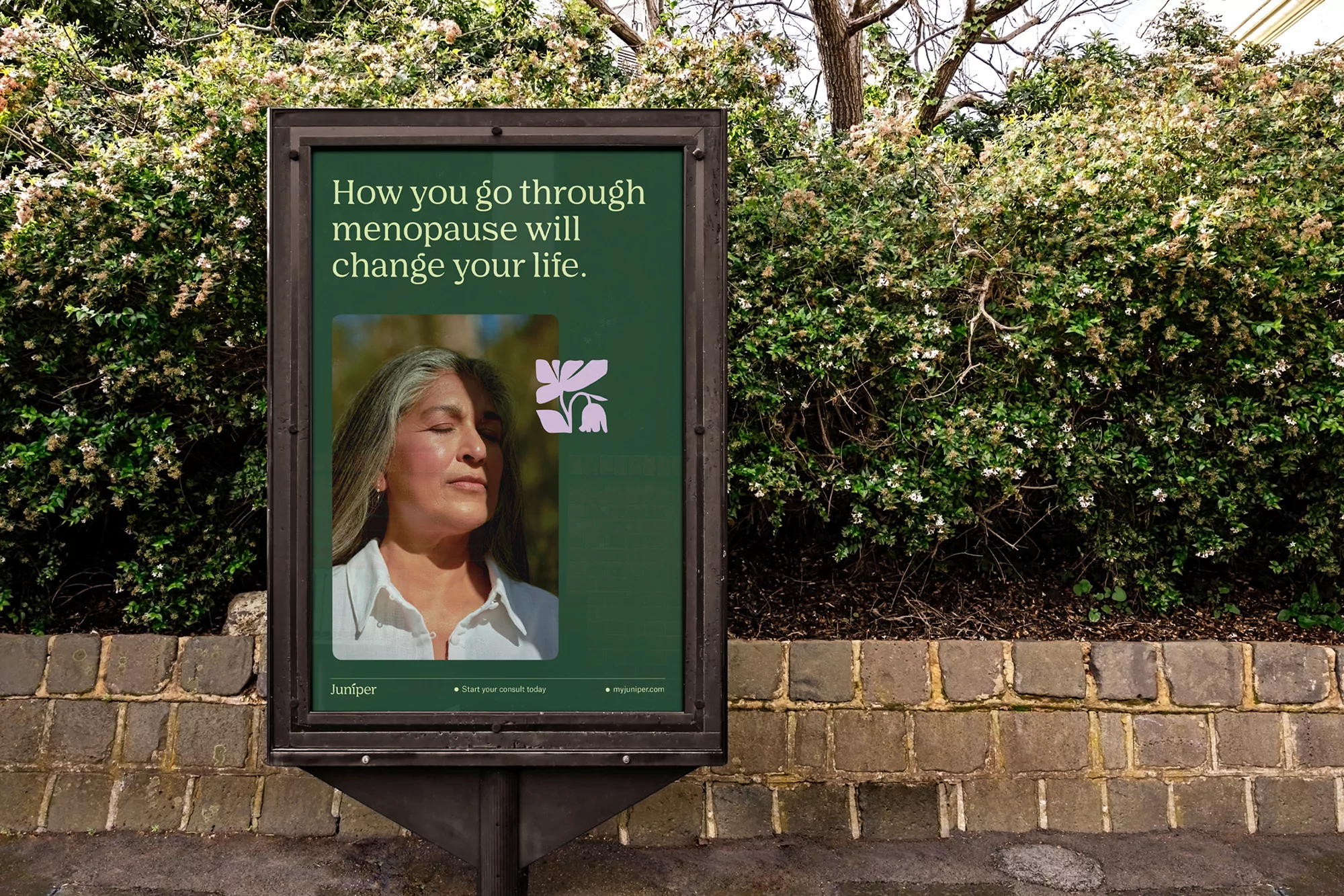Billboard ad featuring an older woman with graying hair on a green background, surrounded by greenery. Advertising the company Juniper.