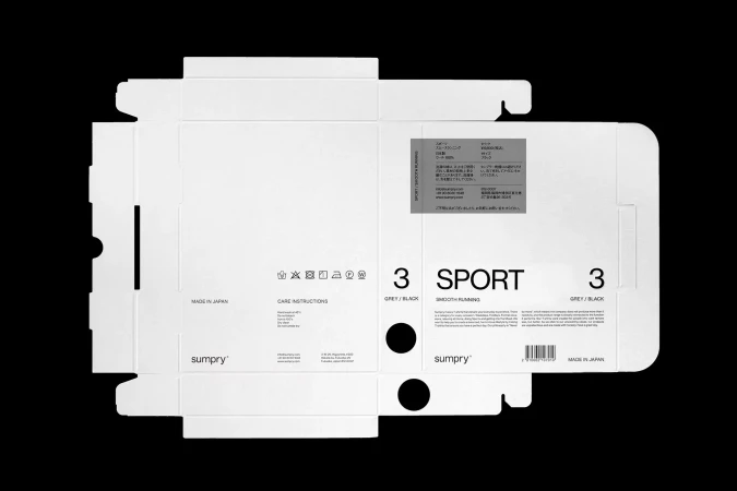 Isolated shot of unfolded sumpry brand packaging box with text '3 SPORT SMOOTH RUNNING' and 'MADE IN JAPAN' on black background.