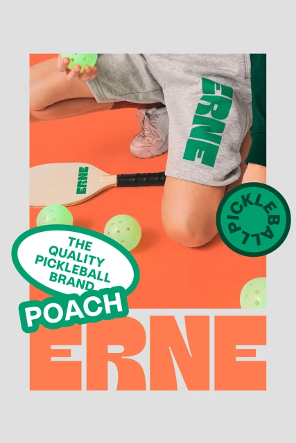 Promotional image of a pickleball set featuring gray athletic shorts, pickleball paddles, and several pickleballs against an orange backdrop.