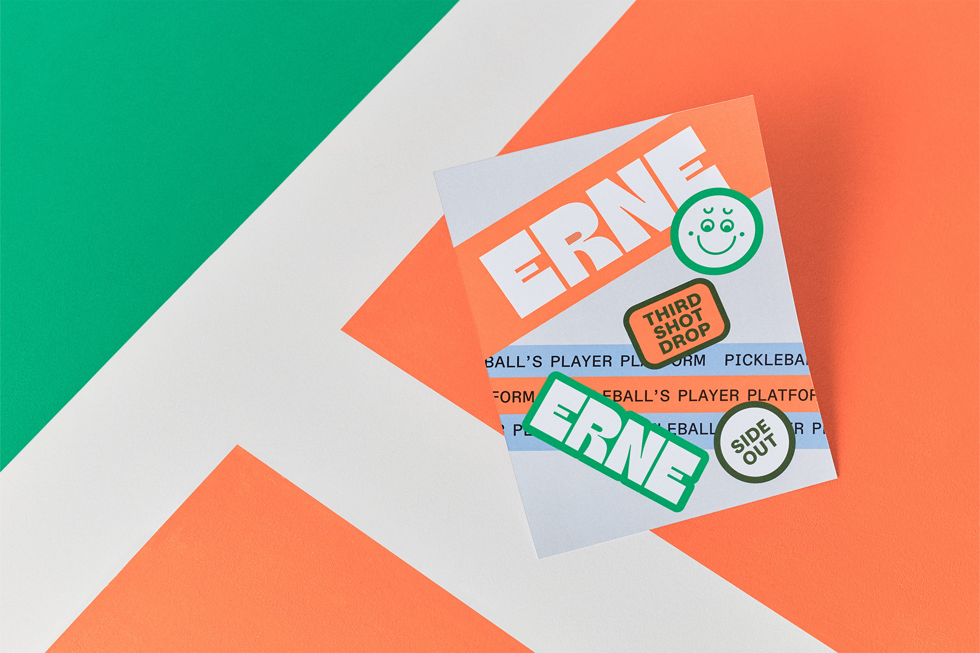 Promotional graphic for Erne, featuring typography, stickers, and geometrical shapes in orange, green, and white on a colorful background.