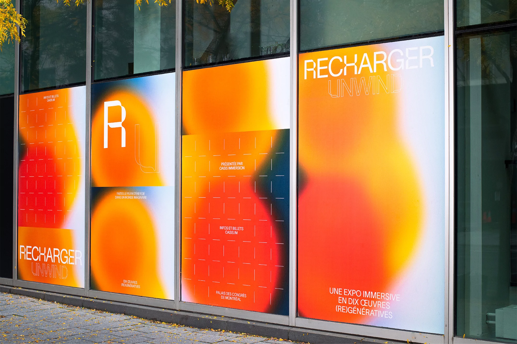 Exterior glass windows featuring vibrant gradient orange and yellow branded window graphics for Recharger Unwind.
