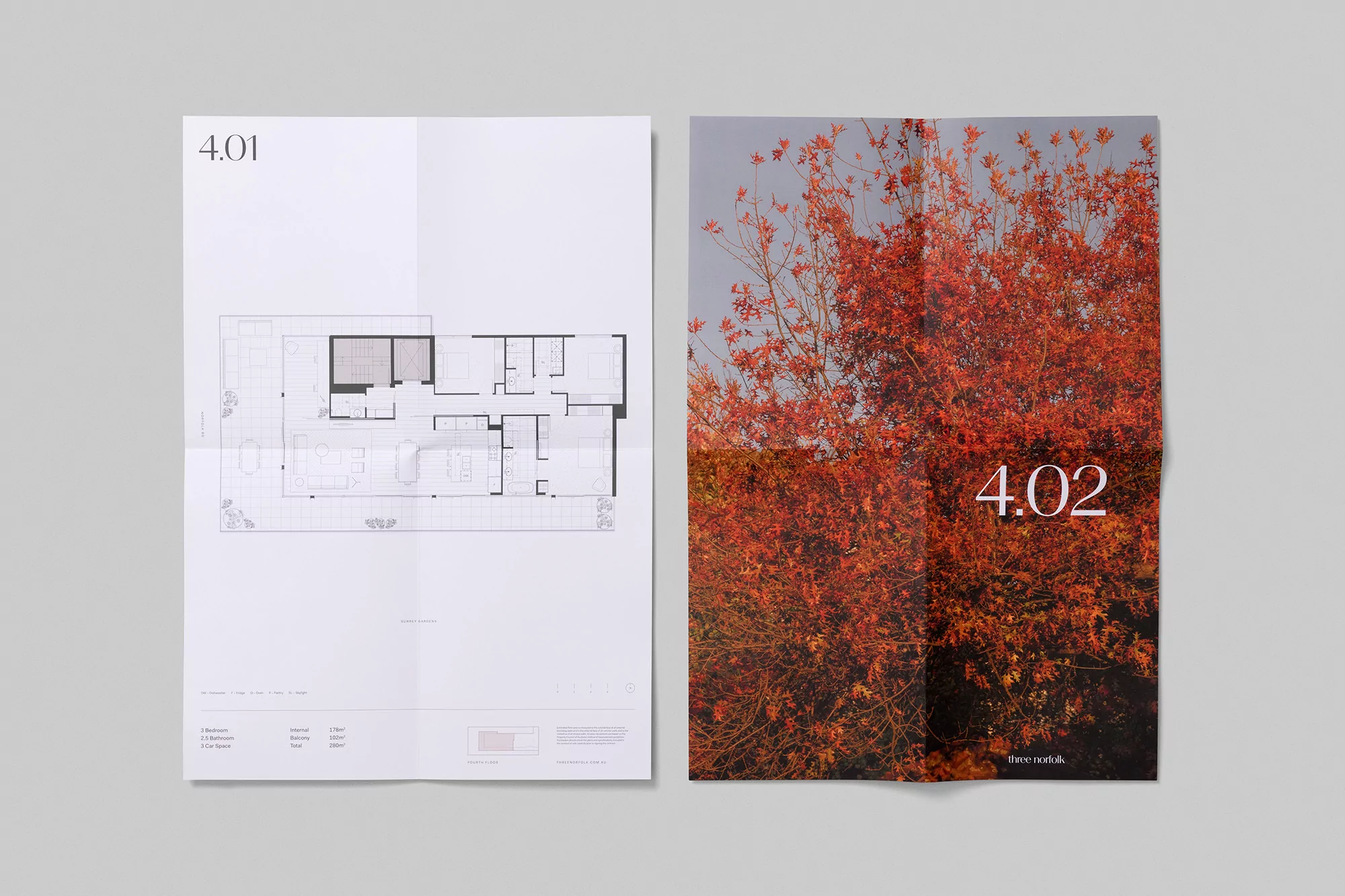 Two architectural plans, one a floor plan, the other a tree in fall color, both on white paper against a gray background.