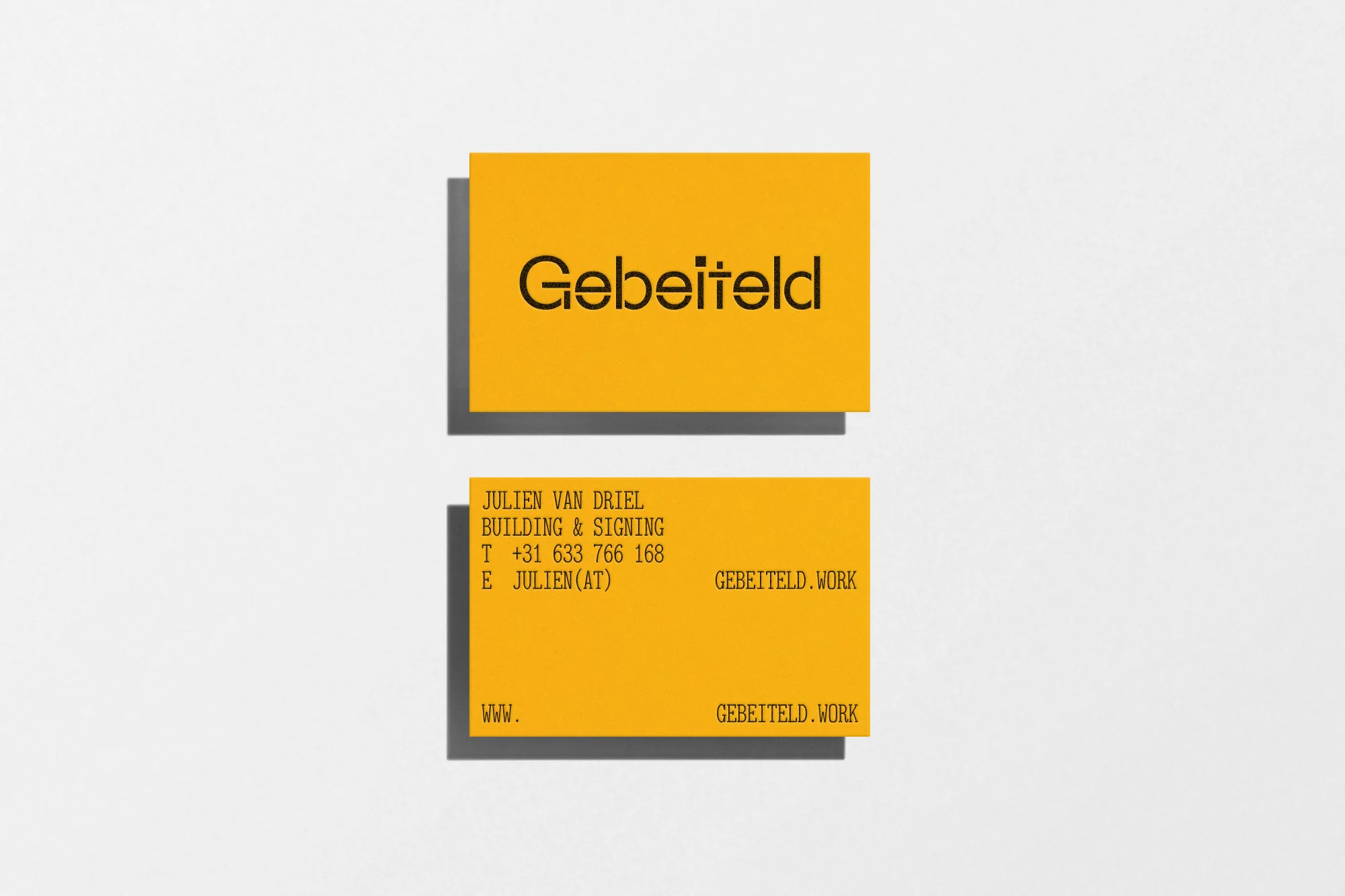 Two yellow business cards with black text, one stacked above the other on a white background with subtle drop shadows.