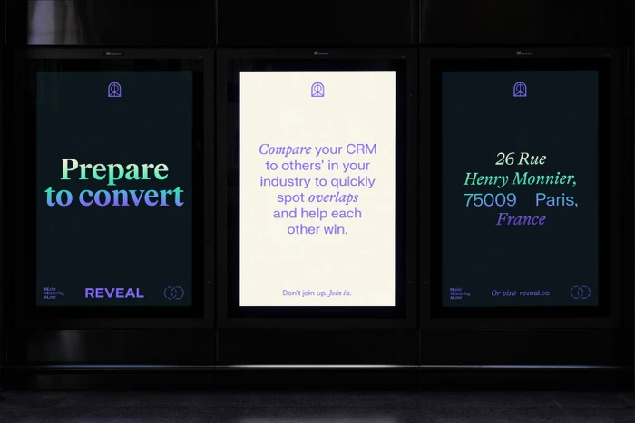 Three vertical digital billboard screens displaying typographic branding for Olami featuring Reveal copy