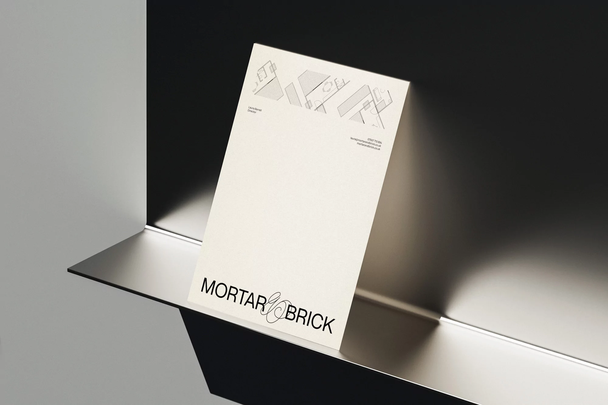 Mortar and Brick company advertisement poster on a silver shelf against a contrasting black and white background in a studio.