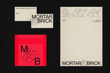 Branding identity mockup featuring business cards, letterhead with floor plan graphics, and a bright red envelope with Mortar and Brick typography