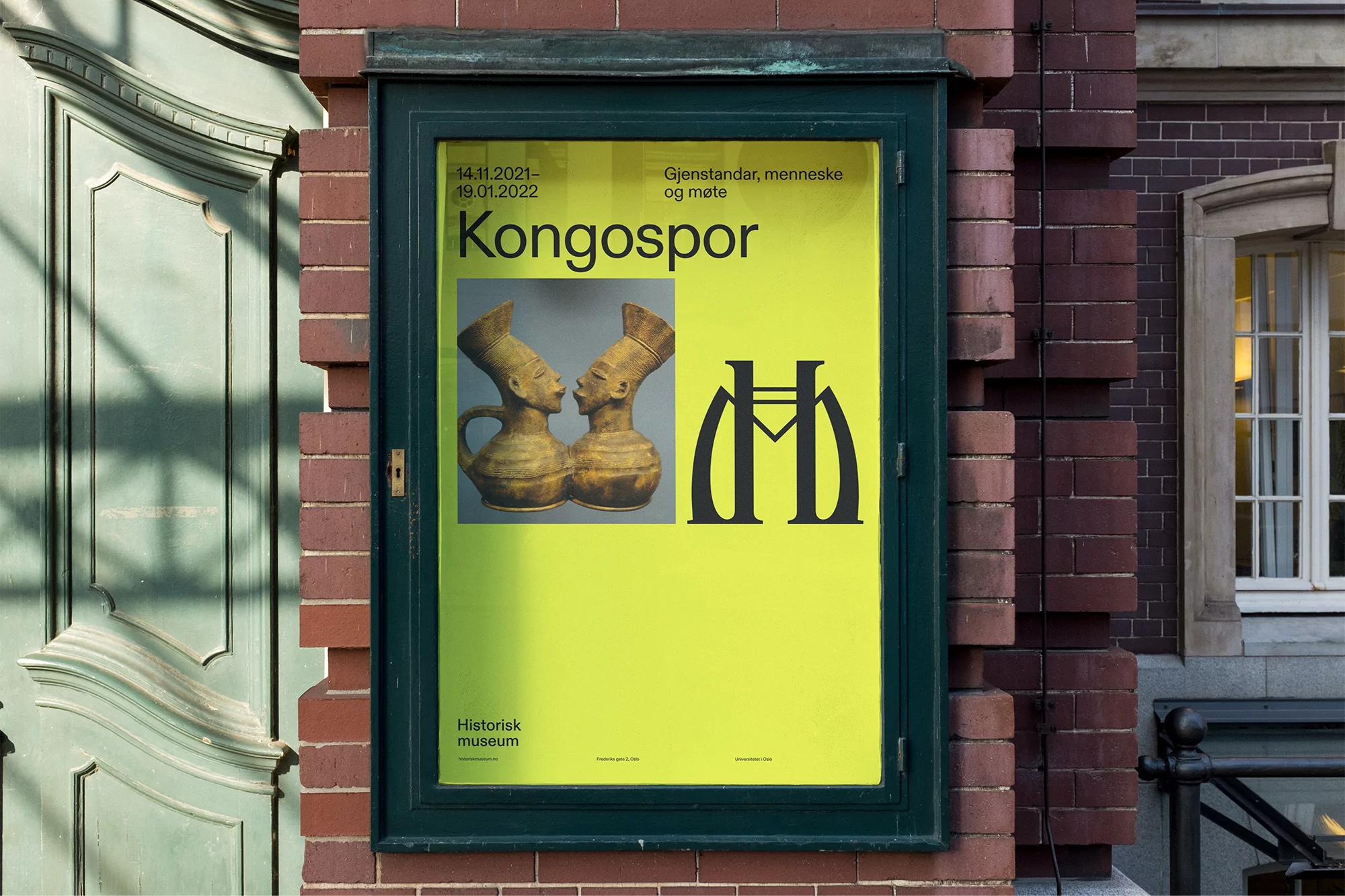 Museum poster featuring two vases resembling human heads with a bright yellow background and dark green frame on a brick building.