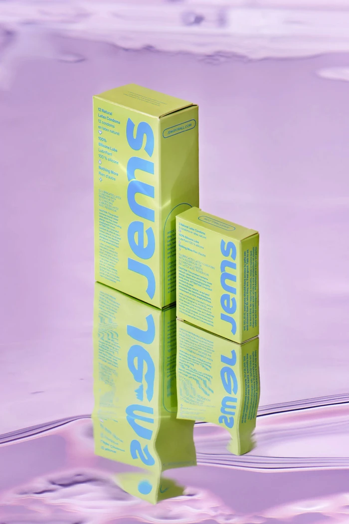 Two yellow product packaging boxes with blue typography resting on a glossy reflective purple surface