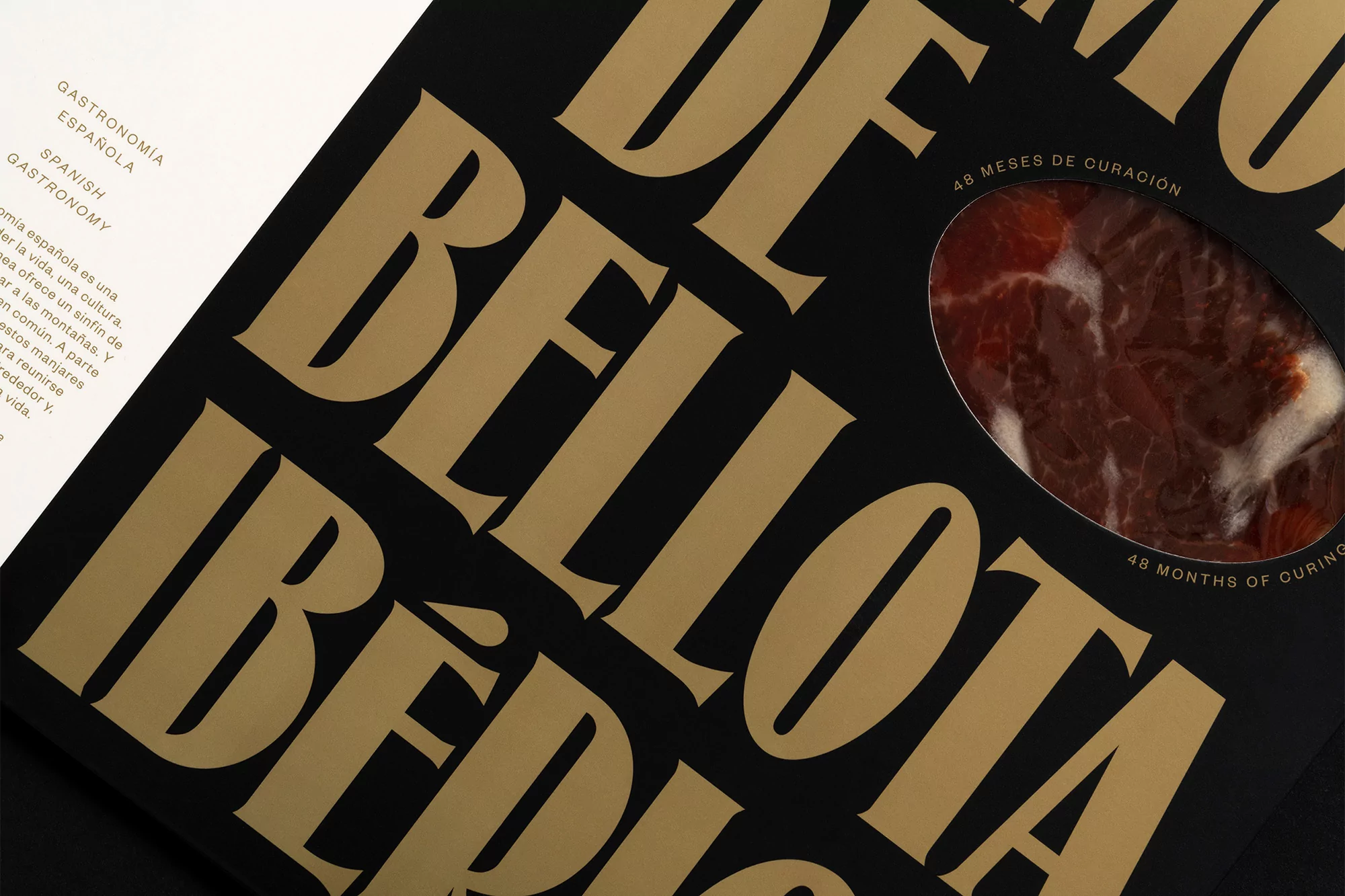 Close-up of a black box of cured Iberian ham with gold lettering and a viewing window showcasing the meat, Spanish gastronomy.