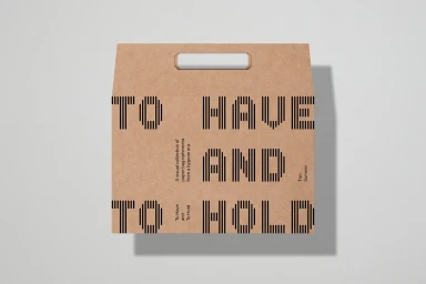 Brown paper carrier bag featuring bold striped black typography and a die-cut handle on a clean light grey background