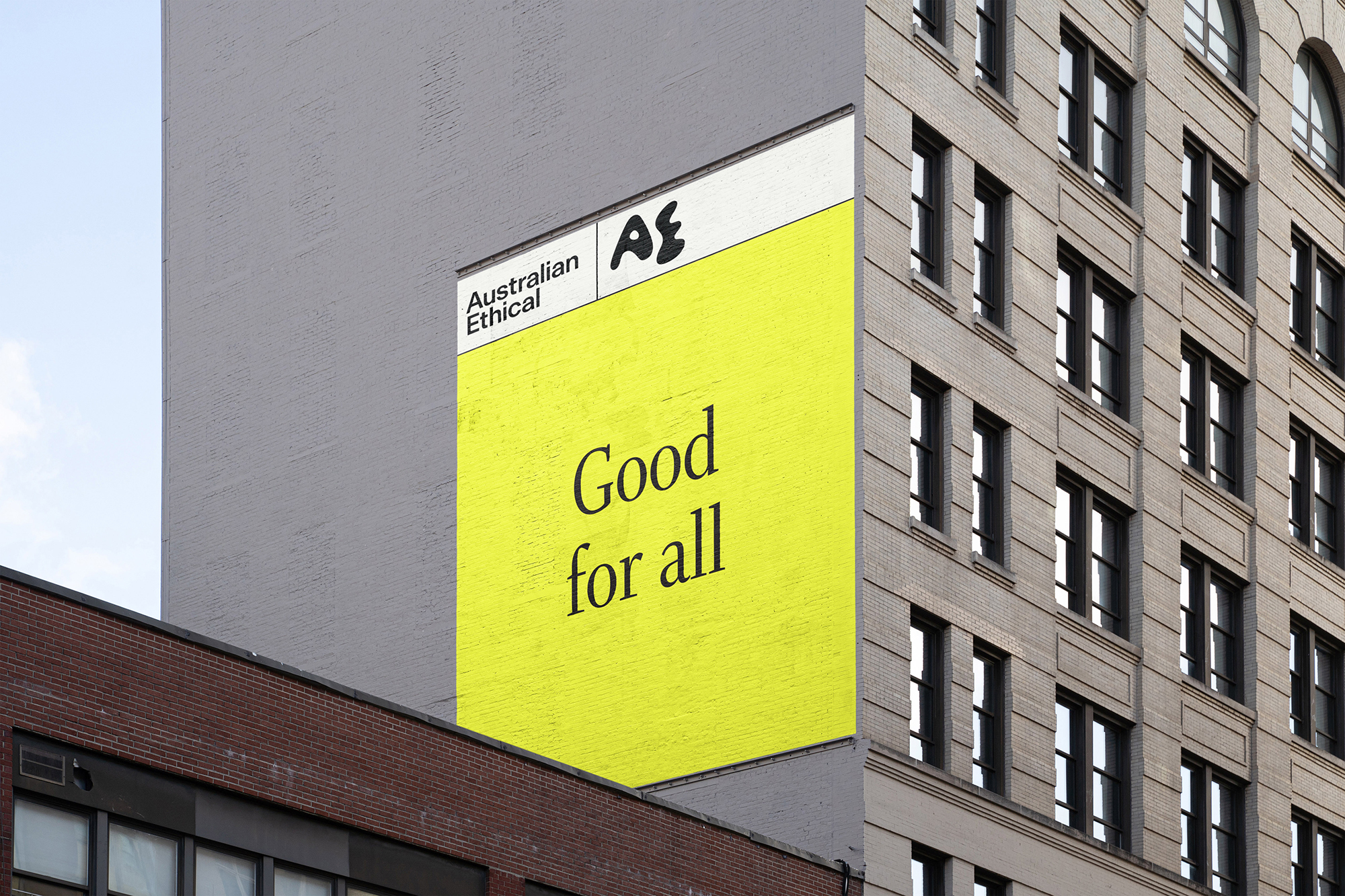 Australian Ethical billboard on the side of a building in a city, promoting 'Good for all' in a bright yellow color.