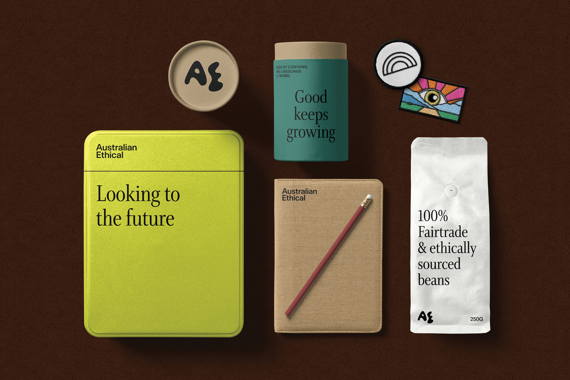 Still life shot of Australian Ethical branded containers and paper products with a brown background in a horizontal composition.