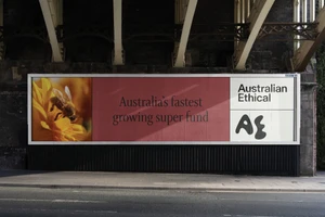 Large billboard advertisement mounted on an urban overpass pillar displaying branding text and a bee on a yellow flower.