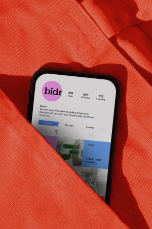 A smartphone displaying a social media profile inside an orange fabric pocket