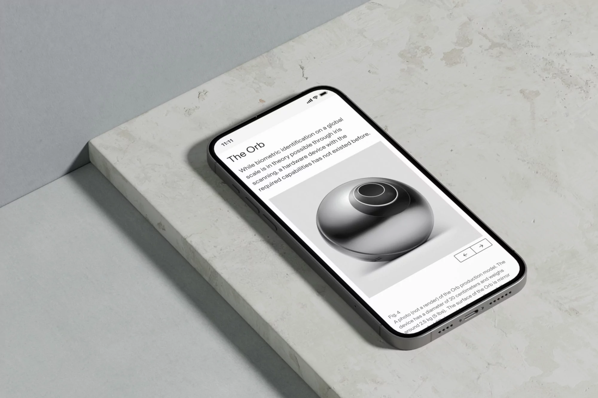 An iPhone displays an article with a metallic orb image, resting on a marble surface. The screen highlights the device's design.