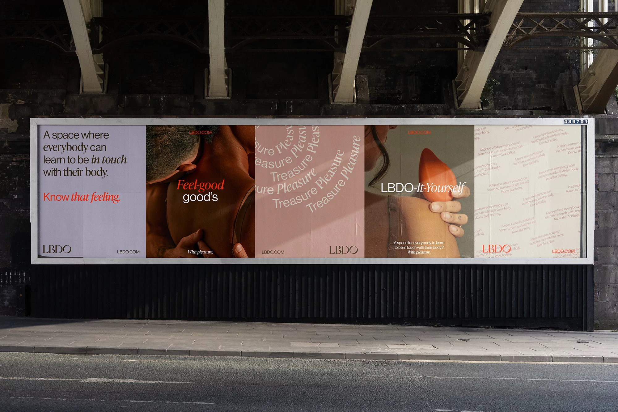 Billboard ad featuring LBDO products and body positivity messaging under a bridge with grey textured ground. Promotes self-discovery.
