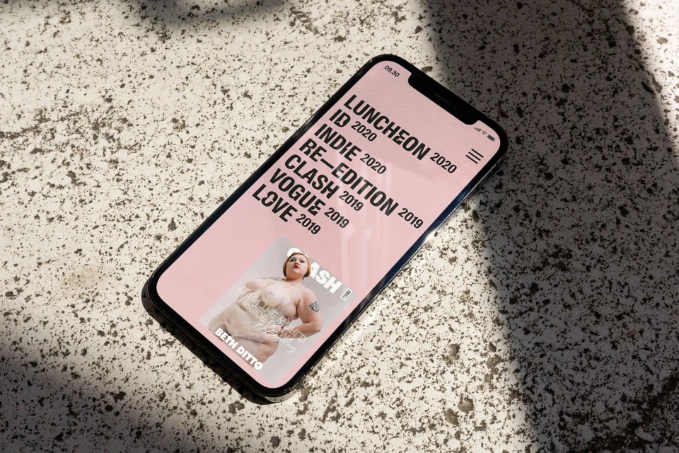 Smartphone screen displays magazine cover with Beth Ditto on textured surface in natural light.