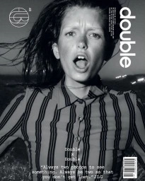 Monochrome portrait of a woman with open mouth wearing a striped shirt against a dark background for Double Magazine