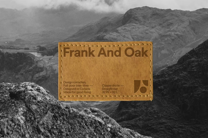 Frank and Oak brand label on a clothing item, displaying the brand name and product information against a mountain backdrop.
