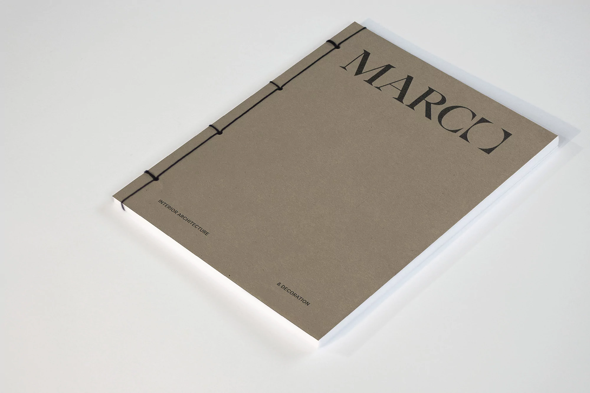 Interior architecture and decoration book with a visible title. Neutral cover, black thread binding, clean design, and neutral backdrop.