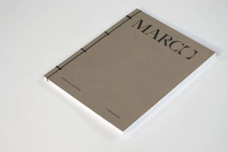 Bound brochure with beige cover and black typography on a clean white surface