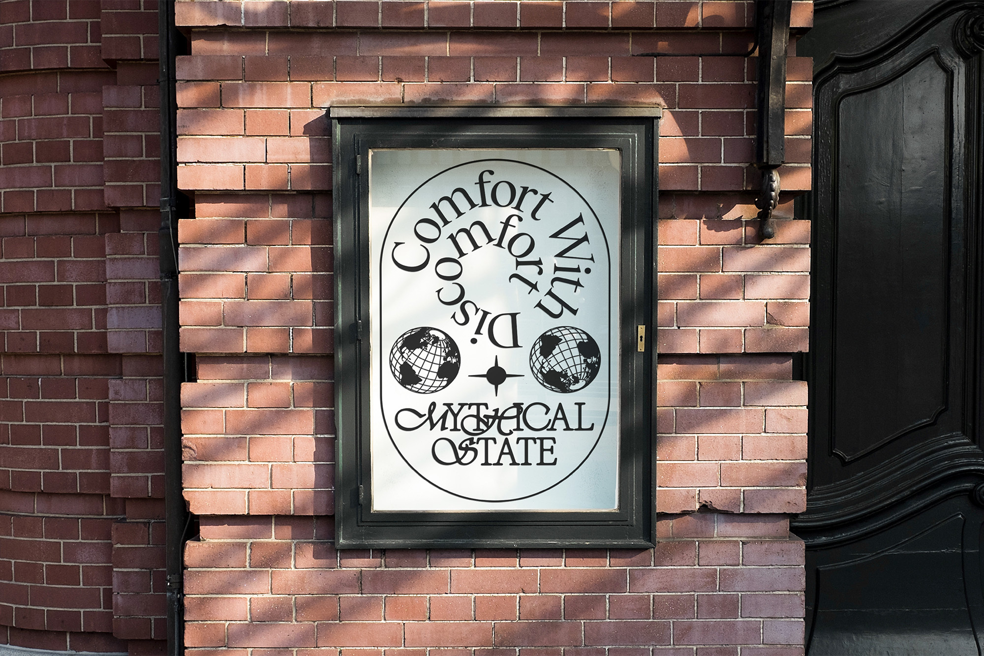 A black framed sign on a brick wall reads, 'Comfort with Disco, Mythical State' with two globes flanking a starburst symbol.