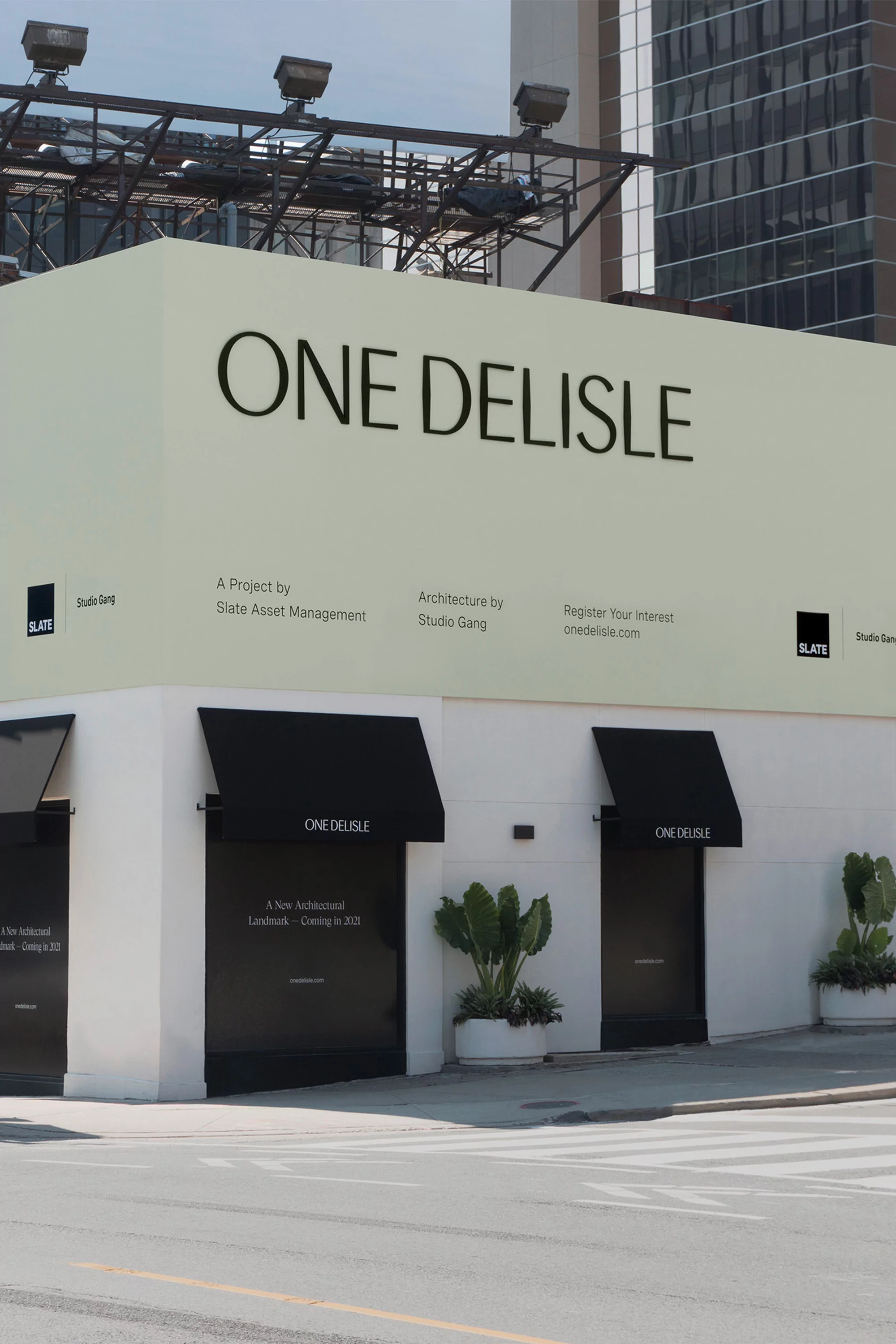 Exterior branding and signage for One Delisle featuring large dark lettering on a pale green and white building facade