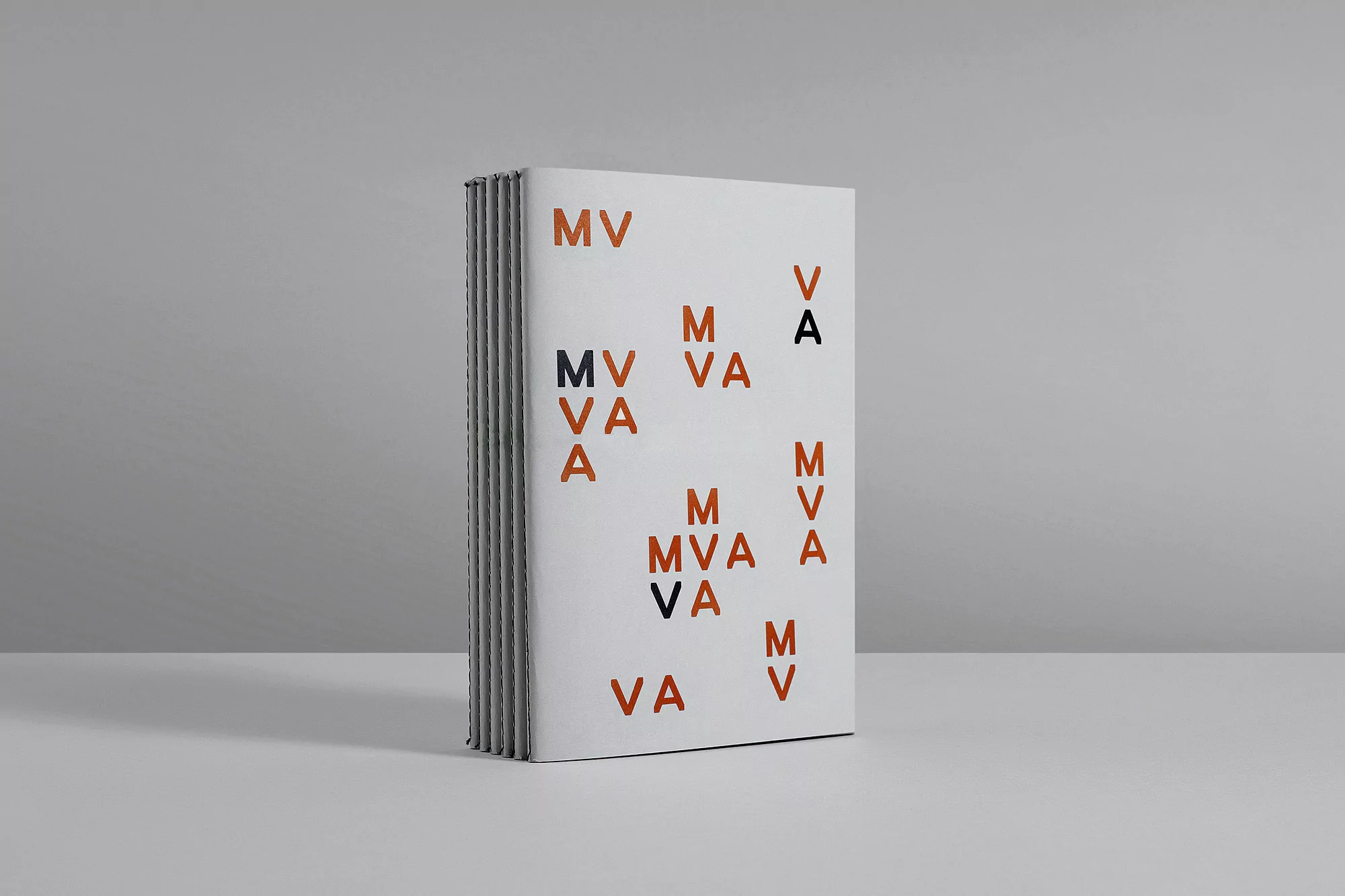 Book cover featuring a modern design with randomly placed letters M, V, and A in terracotta and black against a white background.