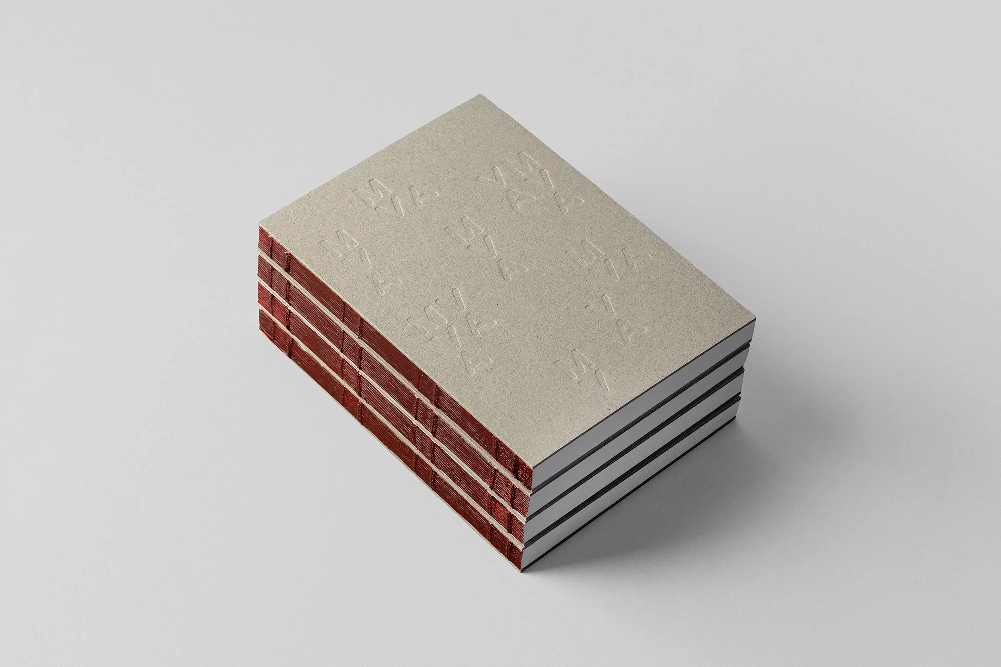 Stack of four identical hardcover books with embossed covers and visible textured pages, isolated on a solid neutral background.