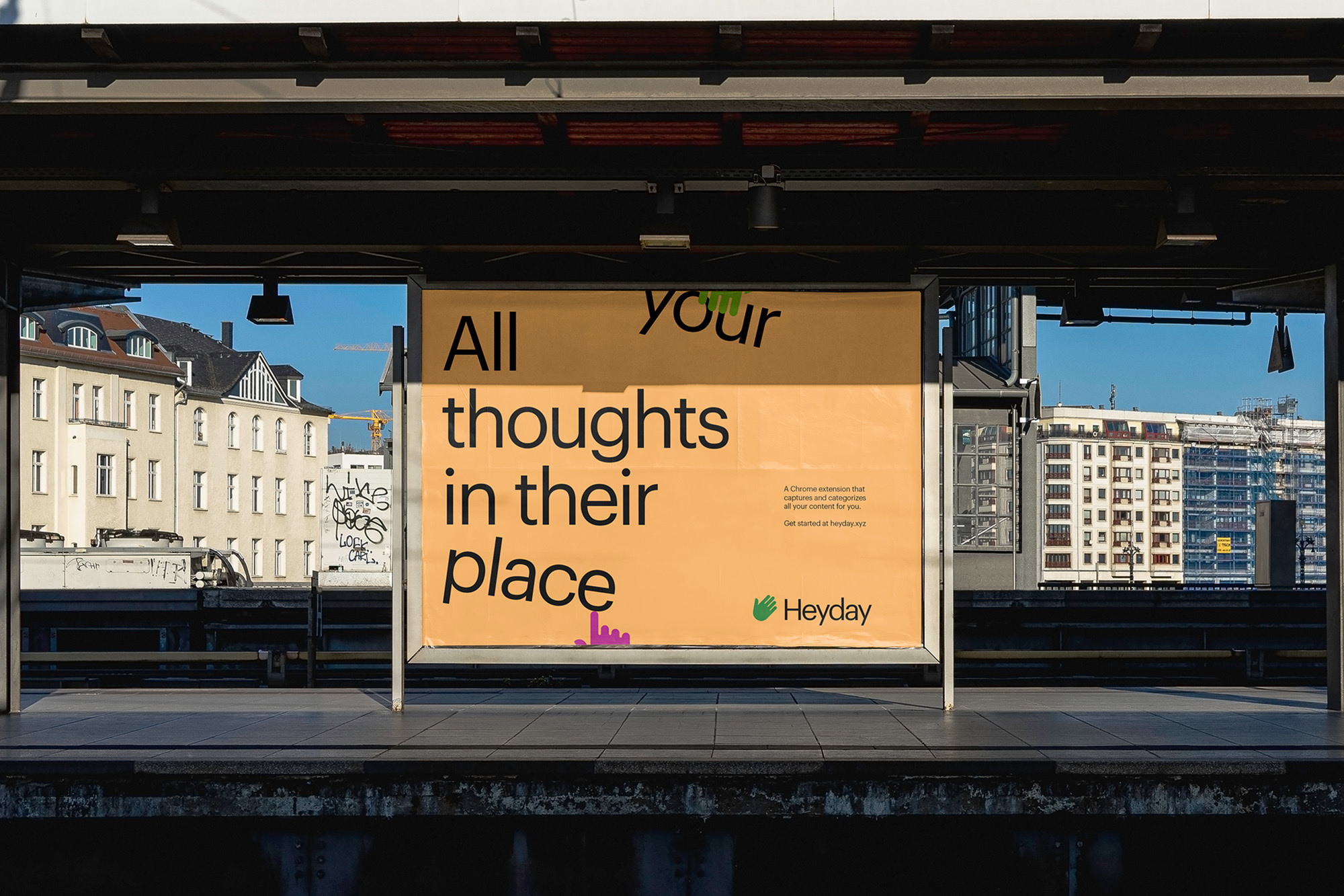 Advertisement for Heyday, displayed at a train station, showing text, the company's logo and a building in the background.