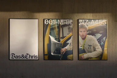 Three framed posters mounted on a textured concrete wall display the brand identity for Bas and Chris with graphic design elements.