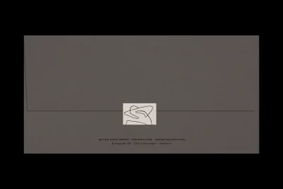 Closed grey paper envelope with a square white seal featuring a black minimalist line art illustration, branded for The Audo