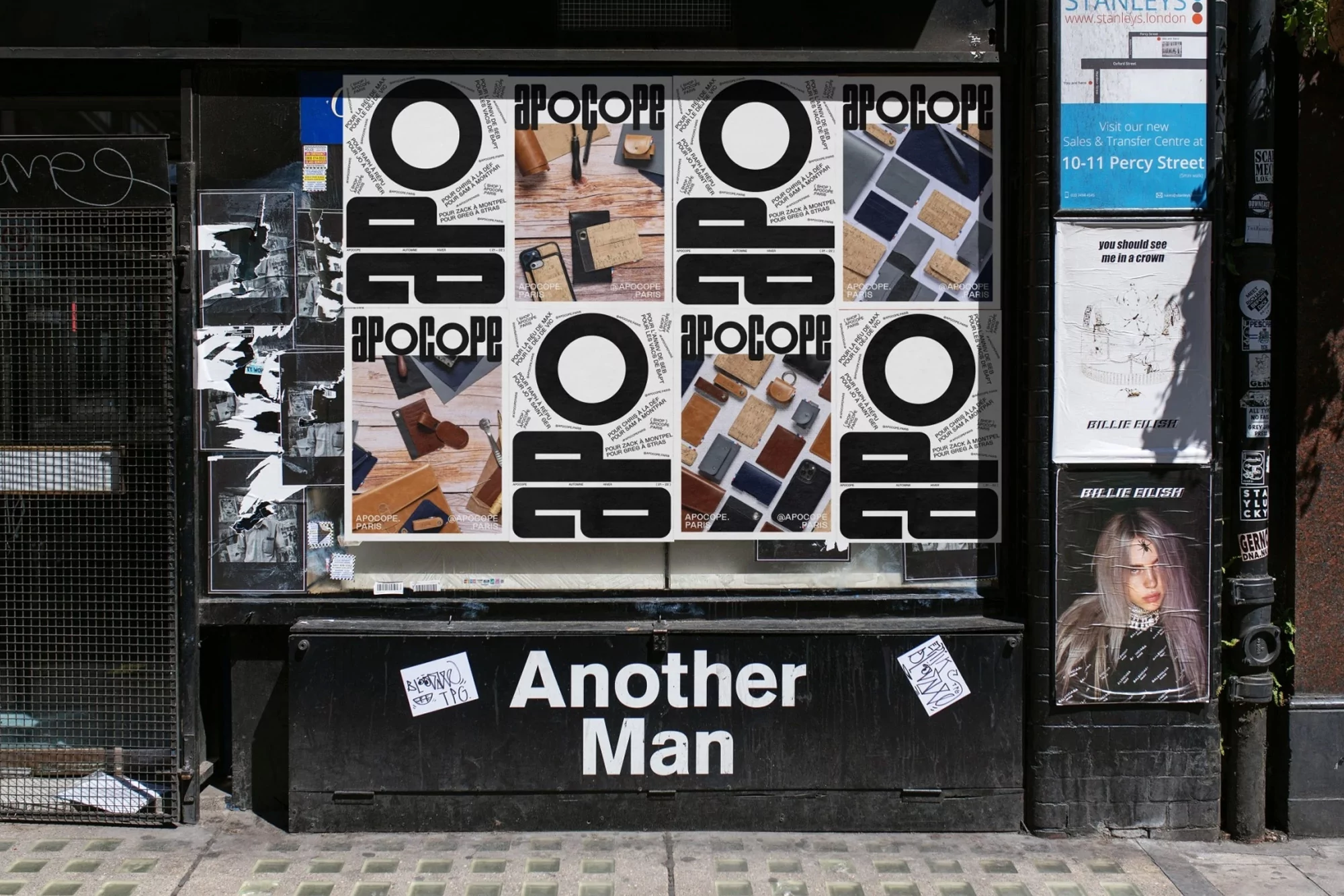 Outdoor view of a shop window displaying APOCOPE posters and other advertisements, with ‘Another Man’ brand name on the facade.