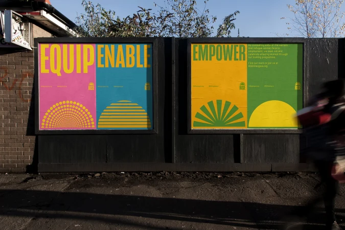 Outdoor poster campaign for Rise mounted on a dark wooden board displaying bold typography and bright geometric motifs.