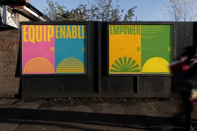 Outdoor poster campaign for Rise mounted on a dark wooden board displaying bold typography and bright geometric motifs.