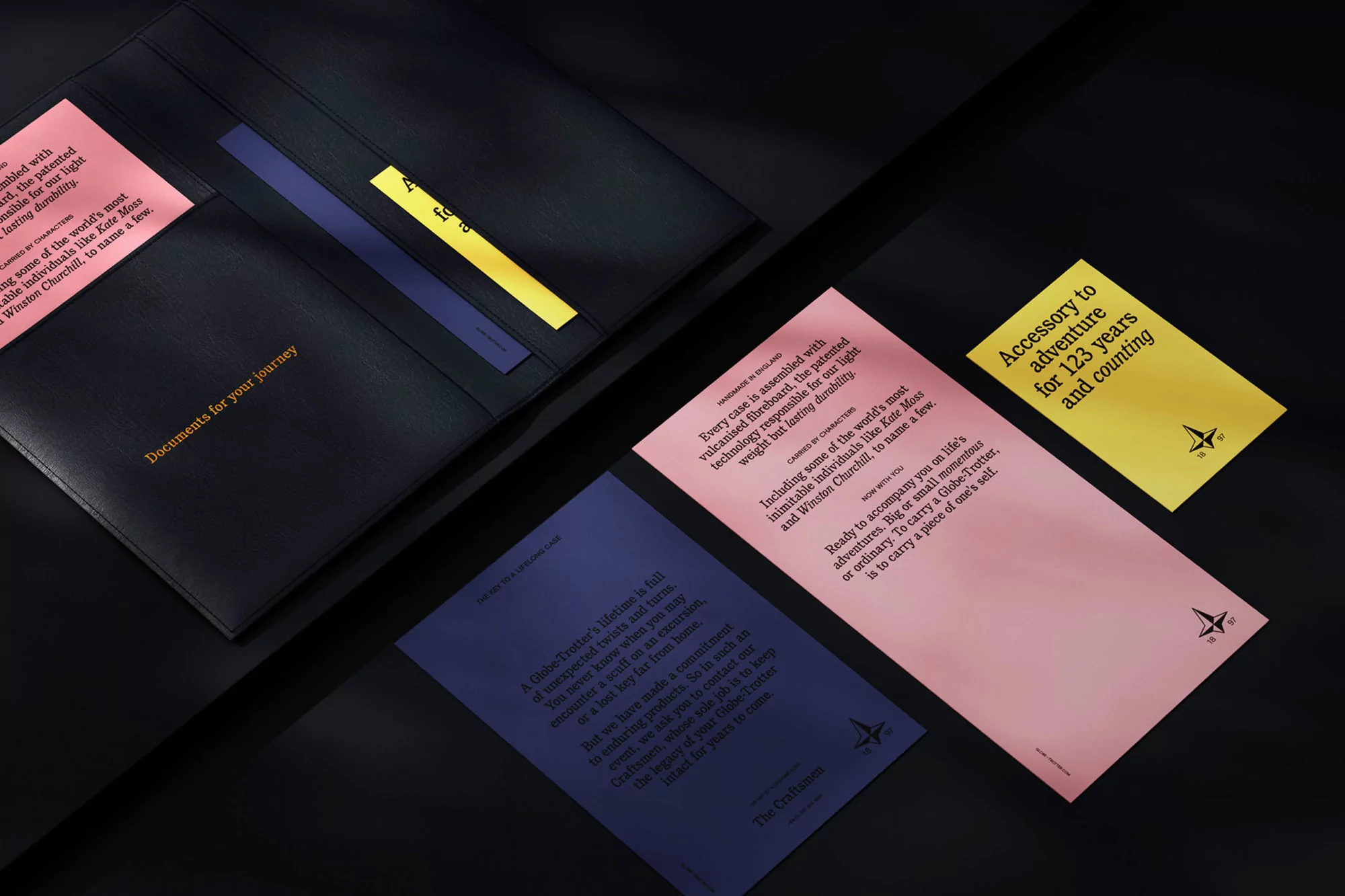 Black leather document holder with colorful paper inserts on a dark surface, showcasing stationery and accessories for travel.