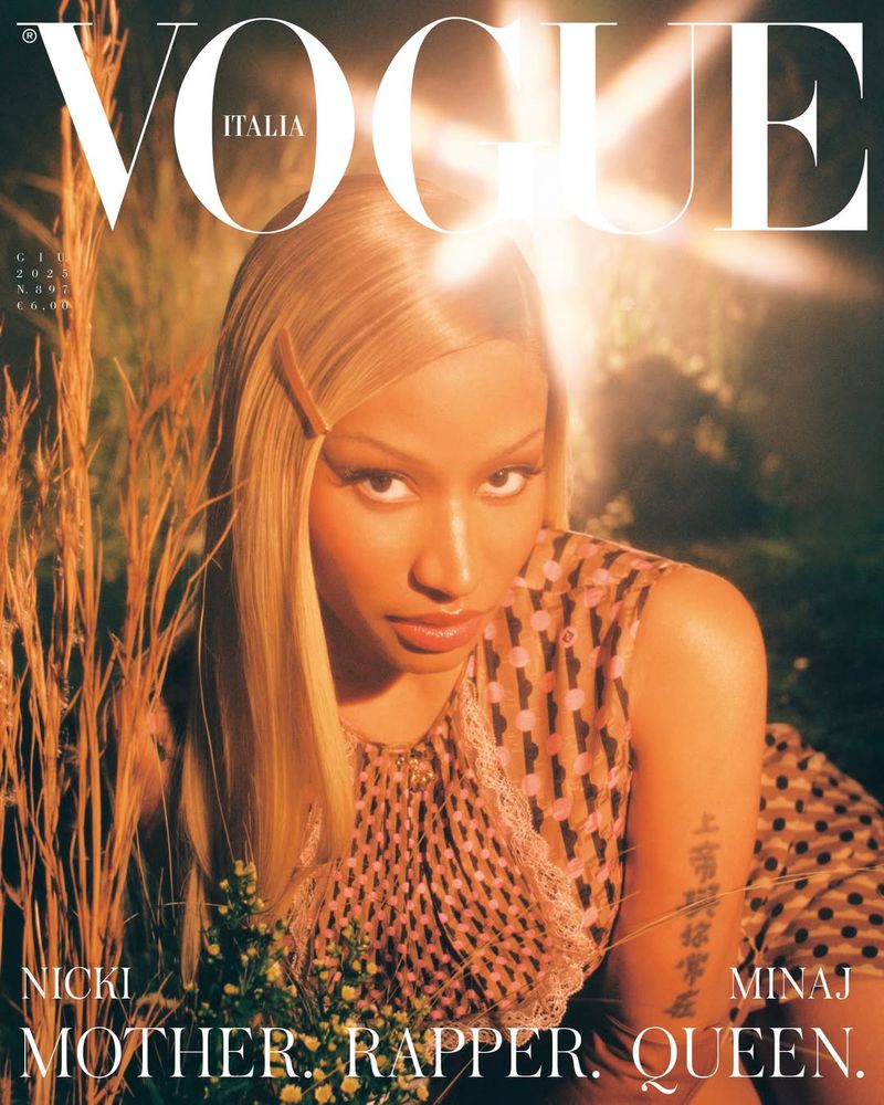 Magazine cover featuring Nicki Minaj wearing a patterned dress, holding flowers, with blonde hair, against a blurred, natural background.