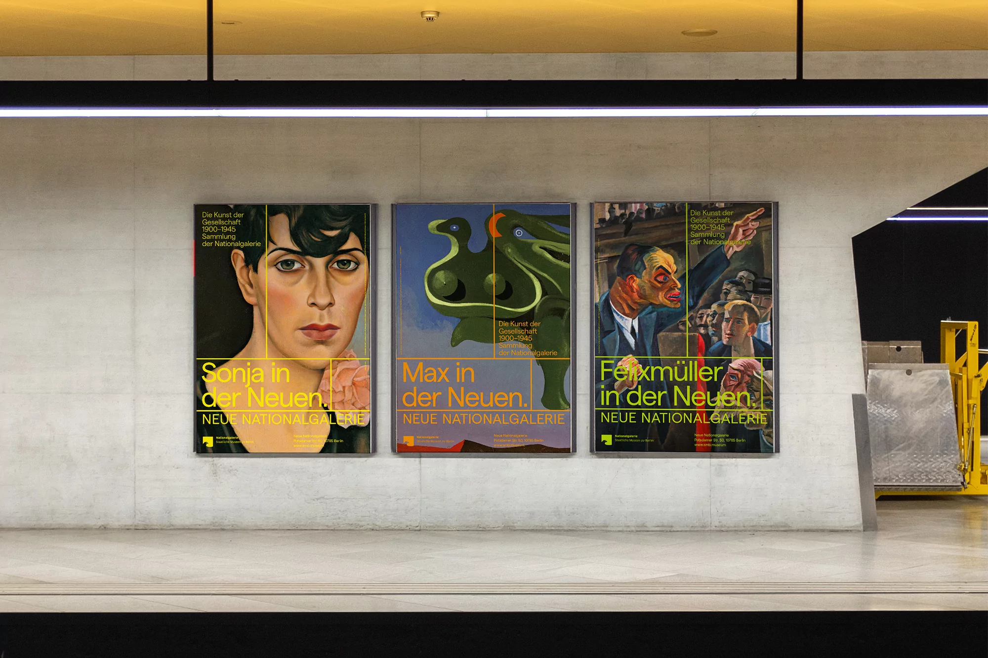 Three framed art posters on a wall inside a transit station. The posters feature portrait and abstract art on display at Neue Nationalgalerie.