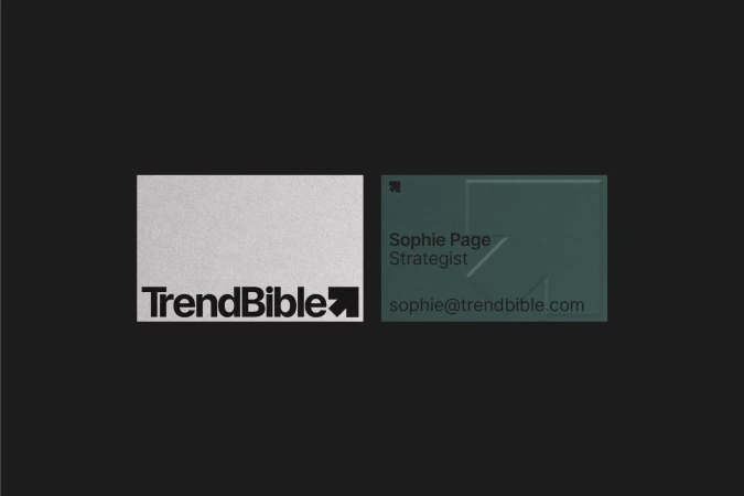 Two business cards side-by-side featuring the TrendBible logo, typography, and minimalist design elements in a studio setting.