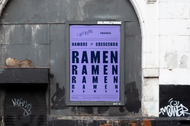 Purple poster featuring bold dark blue RAMEN text displayed on an urban wall for Orchestra Kitchen brand identity.