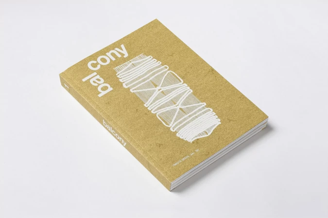 Closed hardcover book with tan cover and white abstract illustration and typography, studio shot against white background, eye-level angle.