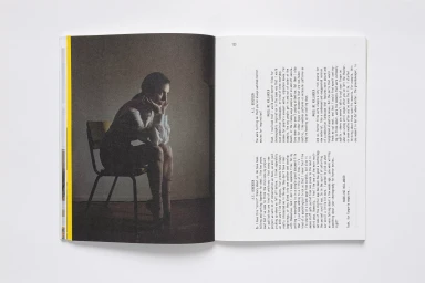 Open magazine spread displaying a seated woman on the left page and columns of printed text on the right page.