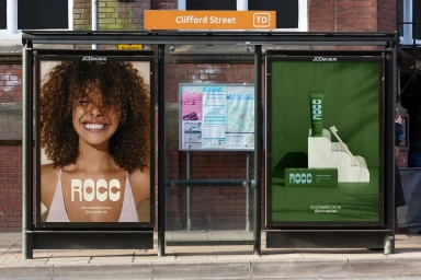 ROCC brand identity advertisements displayed in a glass bus stop shelter on Clifford Street with red brick background