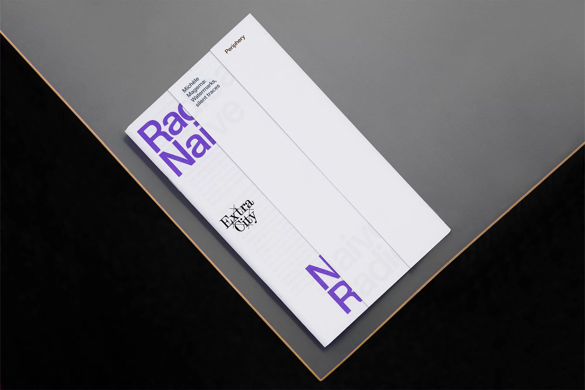 Promotional image featuring a white magazine titled 'Radical Naive' in purple text, set on a grey and black surface.