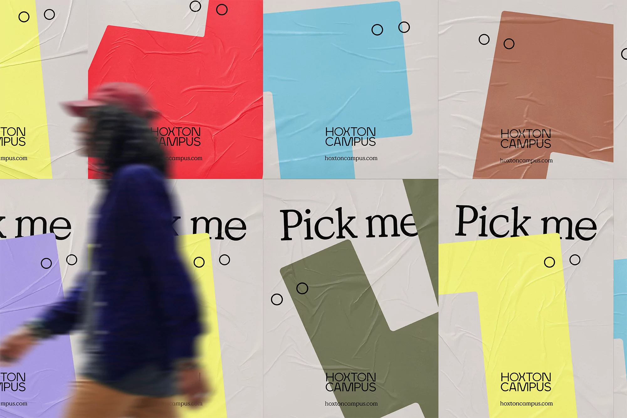 Person walking past a series of colorful promotional posters for Hoxton Campus, featuring the phrase 'Pick me' and geometric designs.