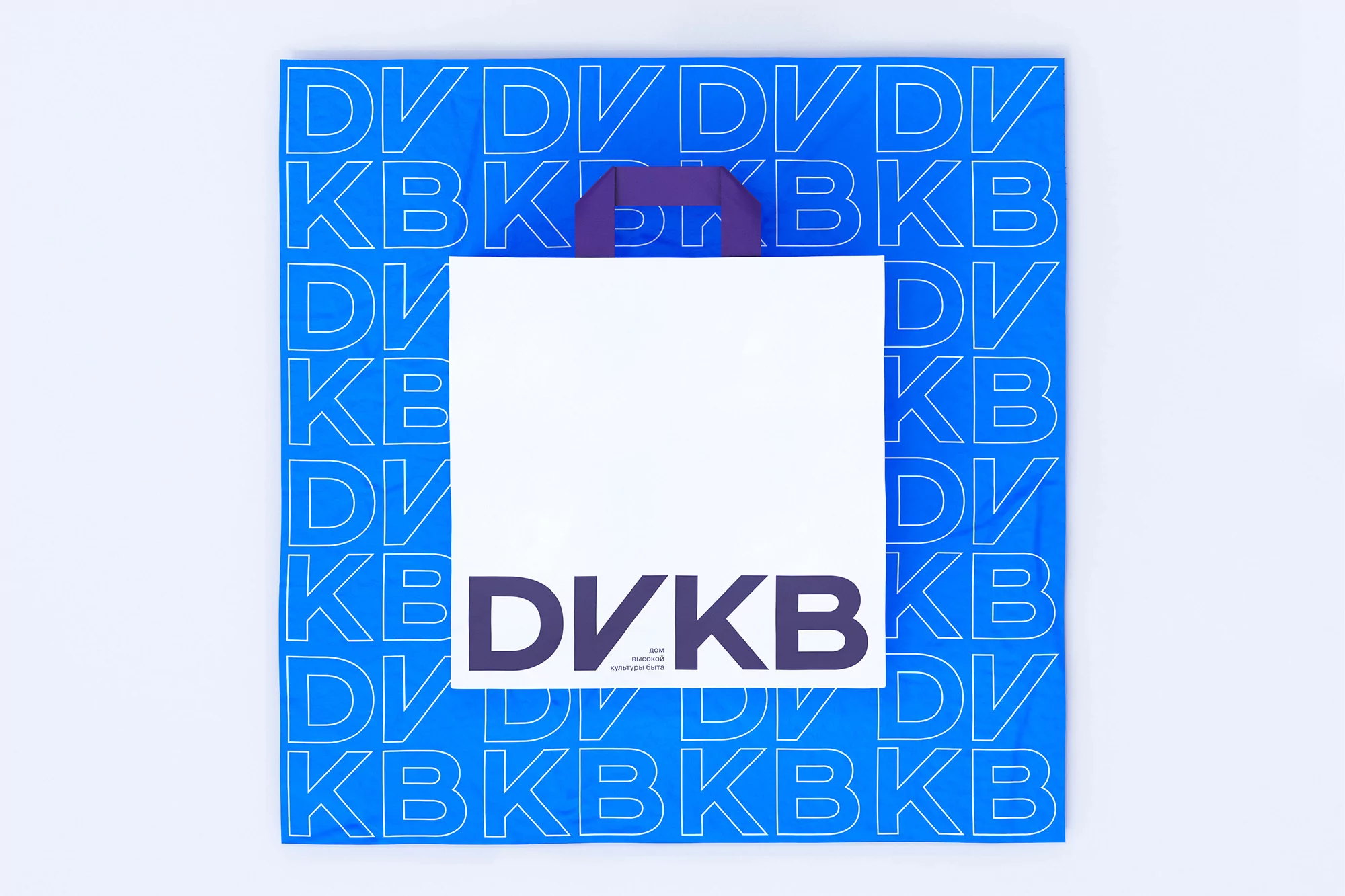 Square shot of a white shopping bag with blue patterned background and purple handles. Isolated image on a white background.