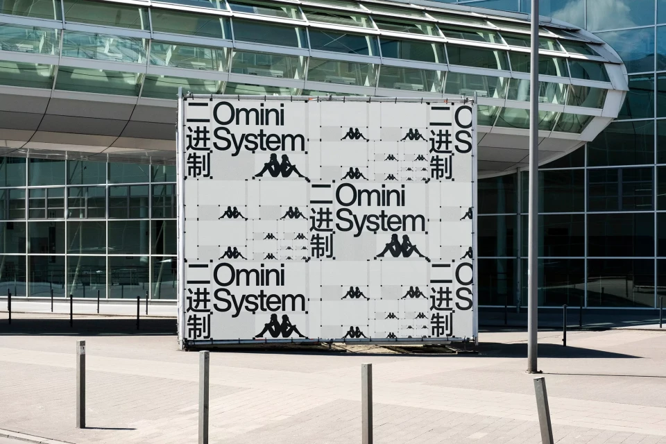 Large Kappa branded banner featuring Kappa logos and Omini System text in front of a glass building, creating a modern urban scene.