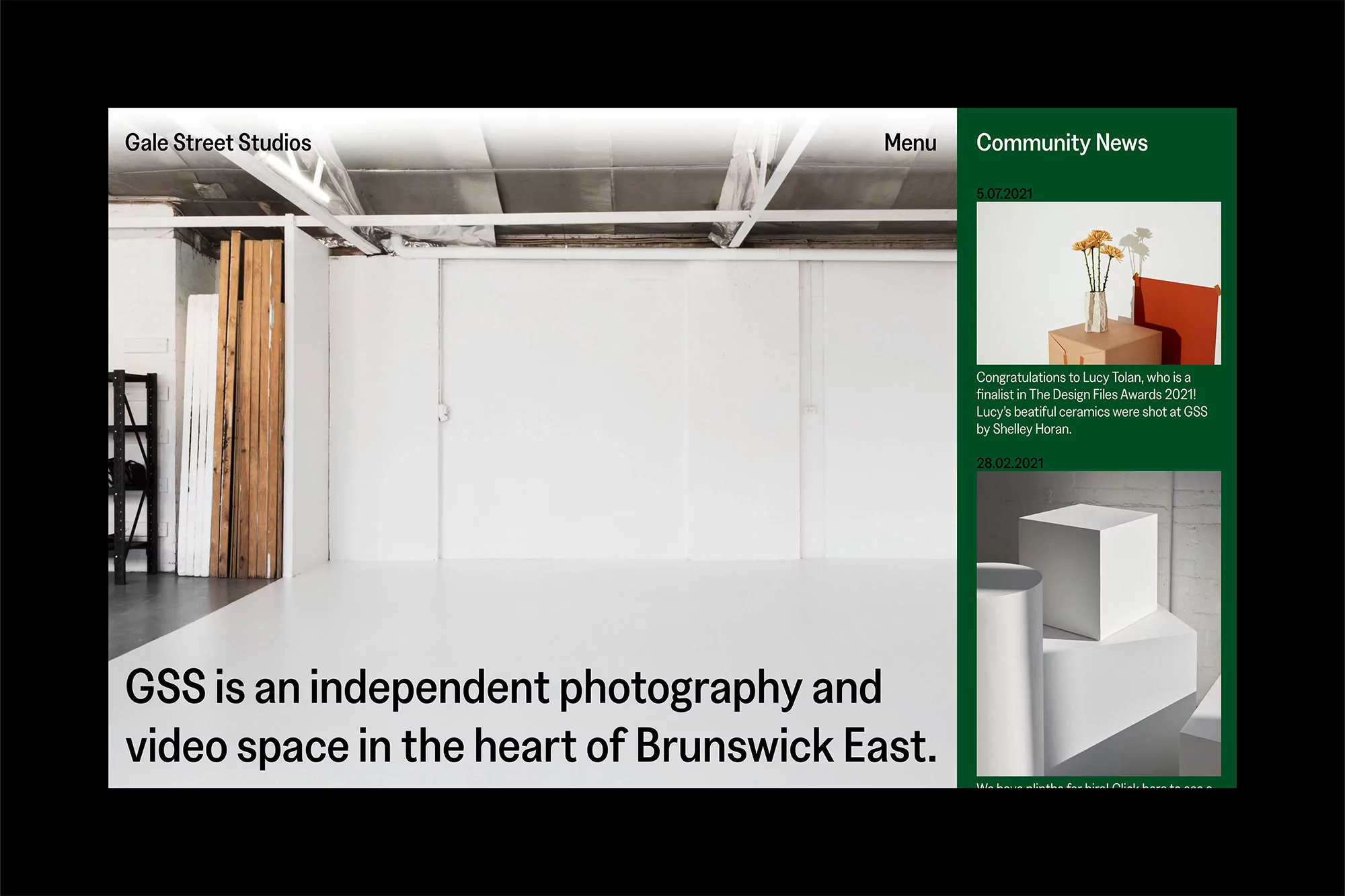Bright photography studio with white walls, natural light, studio equipment and industrial ceiling. Independent photo and video space.